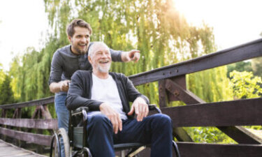 jongere met opa in rolstoel