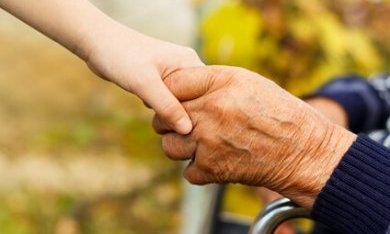 kinderhand houdt de hand van een senior vast