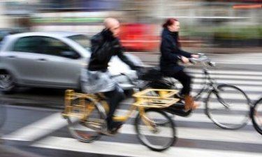 verkeersdrukte met fietsers en automobilisten bij een zebrapad